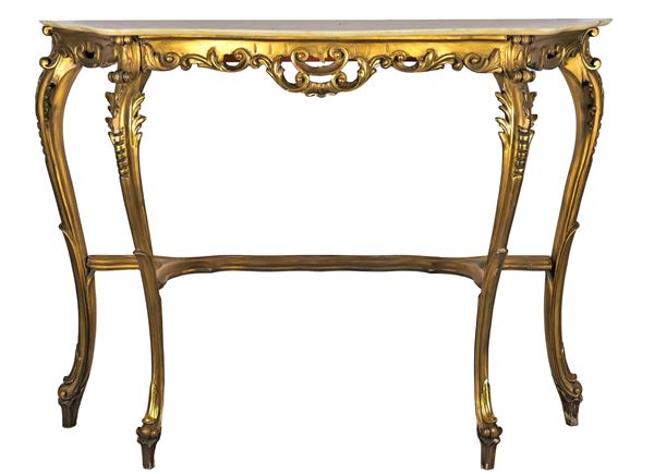 Liberty console in gilded wood carved with leaf and curl motifs, four curved legs joined by a shaped crosspiece and marble top