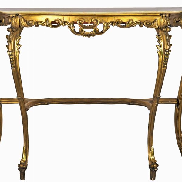 Consolle Liberty in legno dorato e intagliato a motivi di foglie e ricci, quattro gambe ricurve riunite da crociera sagomata e piano in marmo
