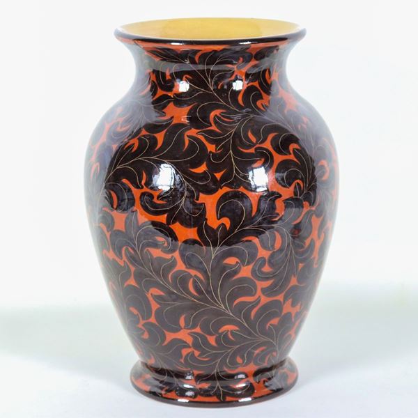 Two-handled glazed terracotta vase marked "La Fenice - Albisola", with foliage decorations on a black background