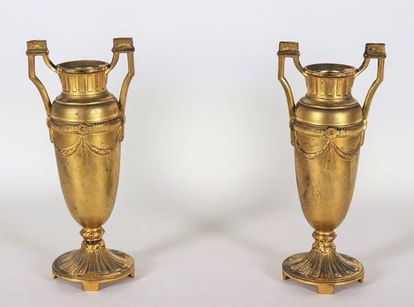Coppia di piccoli vasi francesi a forma di anfore in metallo dorato, sbalzato e cesellato a motivi neoclassici