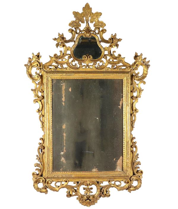 Antica specchiera veneta Luigi XV in legno dorato, con intagli e fregi a motivi di volute di foglie d'acanto e fiori, specchio al mercurio con mancanze