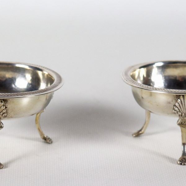 Pair of ancient Neapolitan silver salt shakers in the shape of a tripod, with feet and edges chiselled and embossed with neoclassical motifs, gr. 140