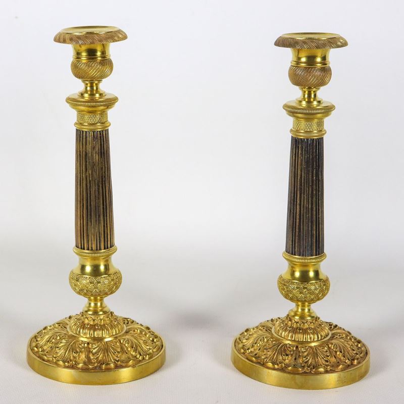 Coppia di antichi candelieri francesi Impero in bronzo dorato, patinato, cesellato e sbalzato, fu...