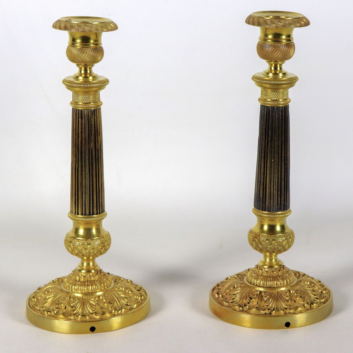 Coppia di antichi candelieri francesi Impero in bronzo dorato, patinato, cesellato e sbalzato, fu...