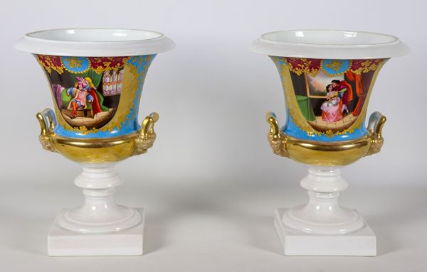Pair of antique French Empire crater vases in Old Paris porcelain, with colorful medallions depicting romantic scenes and bunches of flowers, golden handles in the shape of masks. One vase has cracks and slight defects