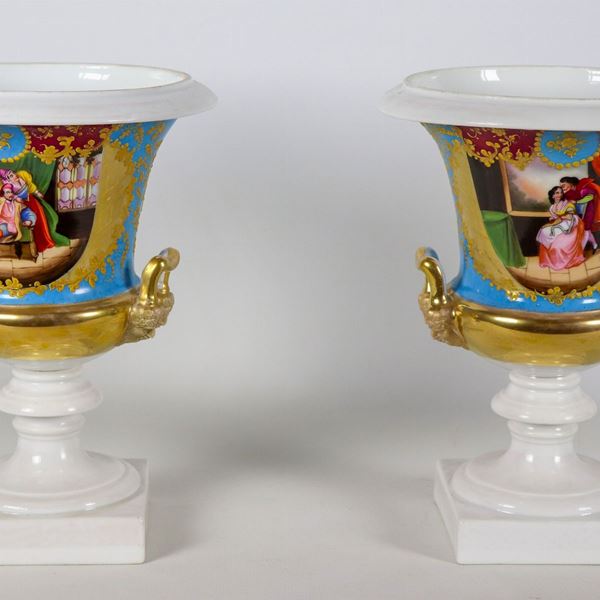 Pair of antique French Empire crater vases in Old Paris porcelain, with colorful medallions depicting romantic scenes and bunches of flowers, golden handles in the shape of masks. One vase has cracks and slight defects