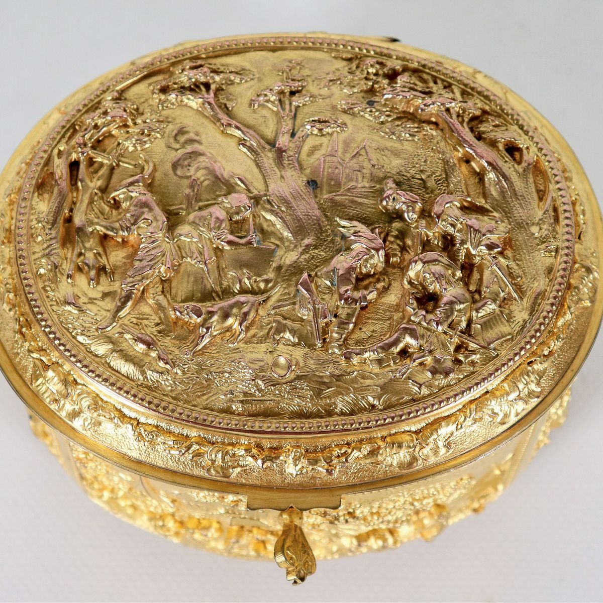 Antica scatola francese ovale in bronzo dorato, interamente cesellata e sbalzata a motivi di paes...