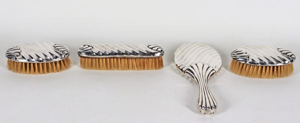 Servizio da toletta in argento cesellato e baccellato, tre spazzole e uno specchio, (4 pz)