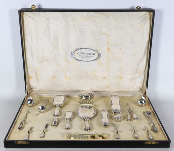 Antique chiseled and embossed silver toilet set, original case (20 pieces). One piece missing