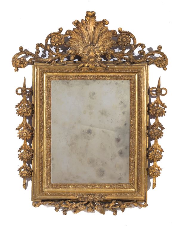 Antica specchiera romana in legno dorato e riccamente intagliato a motivi di ricci, rosoni, conchiglia, calatine di fiori e fiocchi, specchio al mercurio