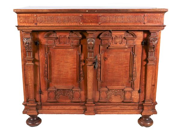 Antique light wood sideboard with carved front, two doors and four onion legs