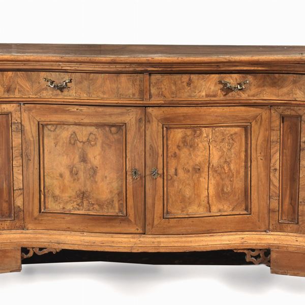 Antica credenza veneta in noce e radica di noce, a forma mossa con angoli sagomati, due tiretti centrali e due sportelli sottostanti. Una parte del piano è stata sostituita