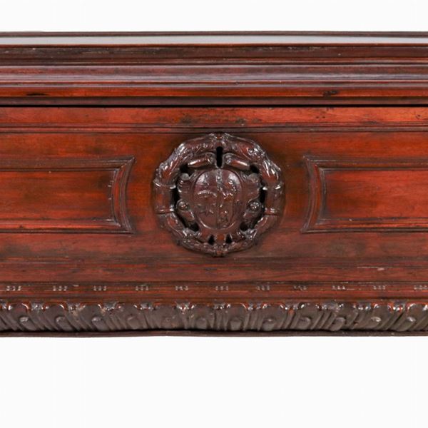 Ancient Umbrian chest in walnut, with carved noble coat of arms in the center and uprights with sculptures of caryatids, legs with lion's paws