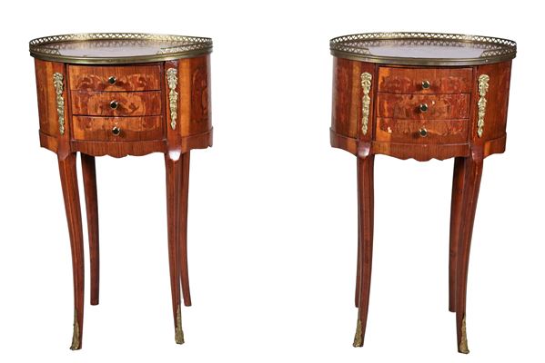 Pair of oval French gueridons in mahogany and bois de rose, with floral scroll inlays, three pullers and four curved legs each