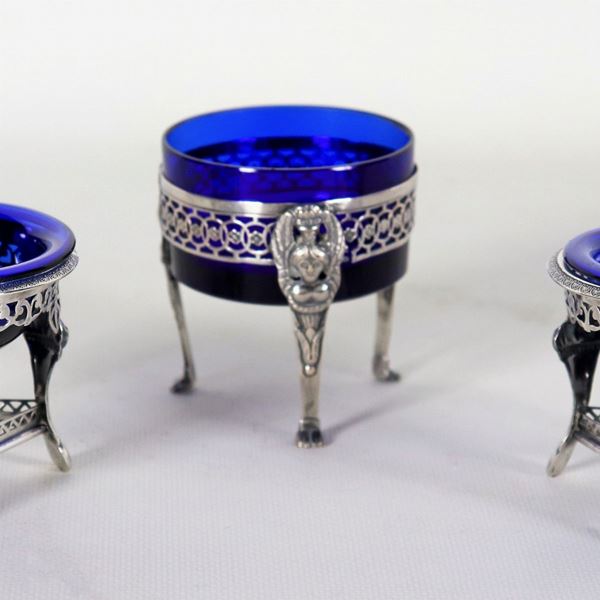 Lotto di tre saliere francesi Epoca Impero in argento, cesellate e sbalzate a motivi neoclassici con vaschette in cristallo blu cobalto, due formano una coppia, gr. 138