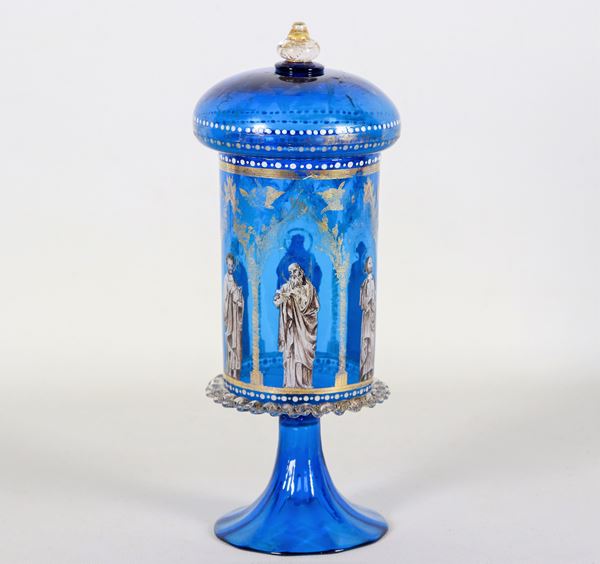 Goblet with lid in light blue Murano blown glass, with golden and enamel applications with figures of "Saints". Slight flaw on the lower edge of the glass