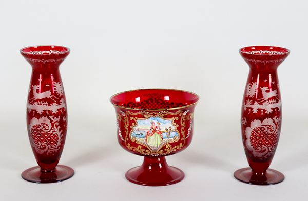 Lotto di due vasetti e una coppa in vetro soffiato di Murano sangue di bue, con decorazioni incise e riquadro in smalto con "Veduta di Venezia", (3 pz)