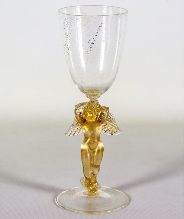 Bicchiere in vetro soffiato di Murano con scaglie dorate, il fusto con figurina di "Putto alato". Un'ala è incollata