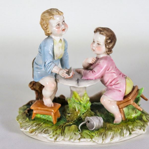 Piccolo gruppo "Bambini che giocano" in porcellana policroma Capodimonte, lievi mancanze