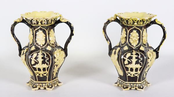 Coppia di antichi piccoli vasi in porcellana nera, con decorazioni chiare a rilievo a motivi di cineserie. I colli dei vasi sono restaurati e lievemente difettati