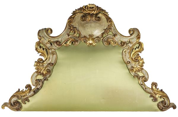 Testata da letto di linea Luigi XV in legno dorato e laccato verde, con intagli a motivi di volute, foglie d'acanto, ricci, conchiglie e fiori