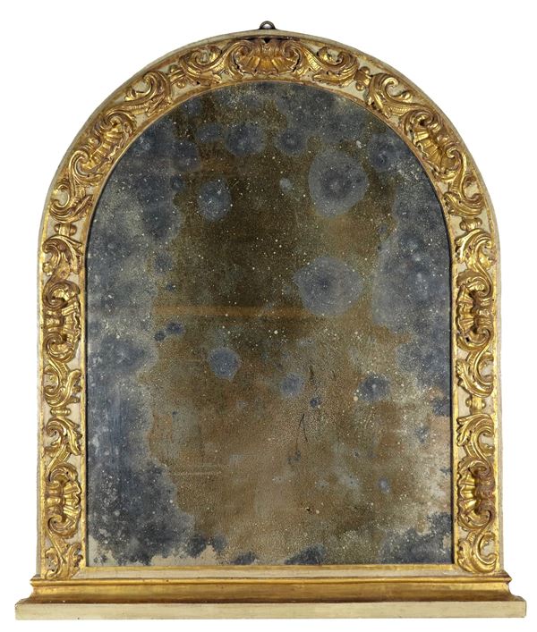 Oval-shaped mirror in gilded and green lacquered wood, with carvings of acanthus leaves, sea urchins and shells, mercury mirror