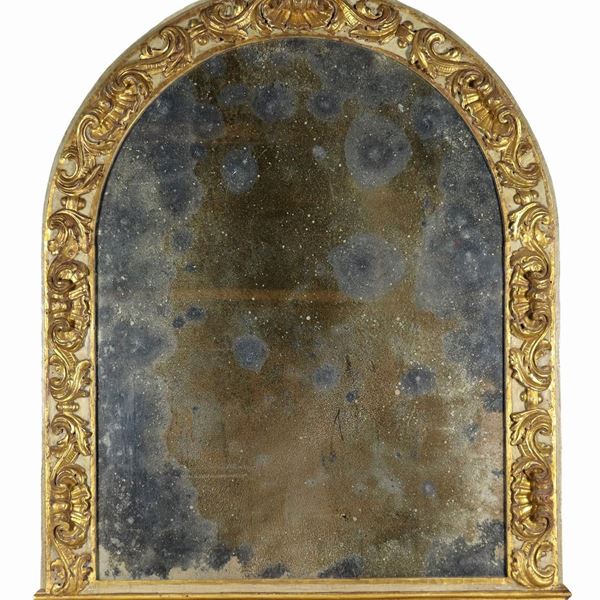 Specchiera a sesto ovale in legno dorato e laccato verde, con intagli a motivi di foglie d'acanto, ricci e conchiglie, specchio al mercurio