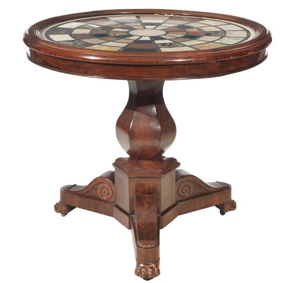 Roman Empire center table with a round shape, in mahogany and mahogany feather, with top in various precious marbles with geometric inlays, faceted column base, resting on three curved legs ending in a lion's paw
