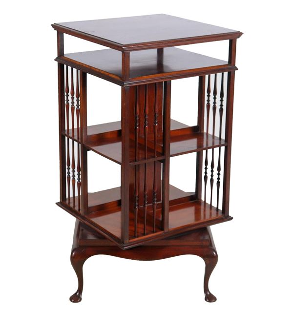 English revolving bookcase in mahogany feather and mahogany, square shape with compartments and dividers with turned columns, four curved legs