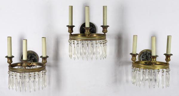 Lot of three French Empire line appliques in embossed bronze, circular shape with faceted crystal pendants, 3 lights each