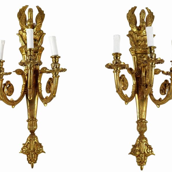 Coppia di appliques francesi in bronzo dorato, sbalzato e cesellato a forma di faretra con sculture di cigni, 3 luci ciascuna