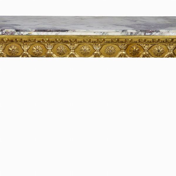 Consolle francese di linea Luigi XVI, in legno dorato e intagliato a motivi di fiocchi e rosoni, quattro gambe a cono scannellato e piano in marmo grigio venato