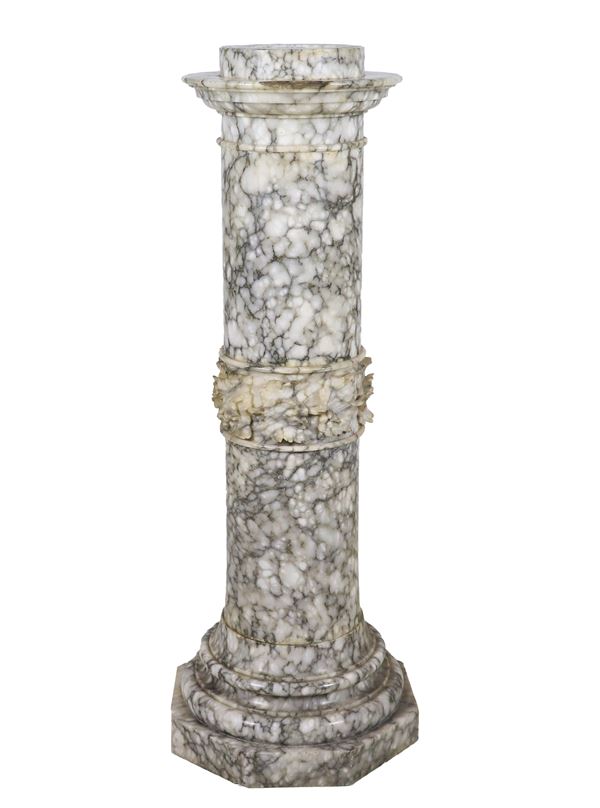 Colonna tonda rivestita in marmo grigio venato, con struttura interna vuota. Lieve mancanza