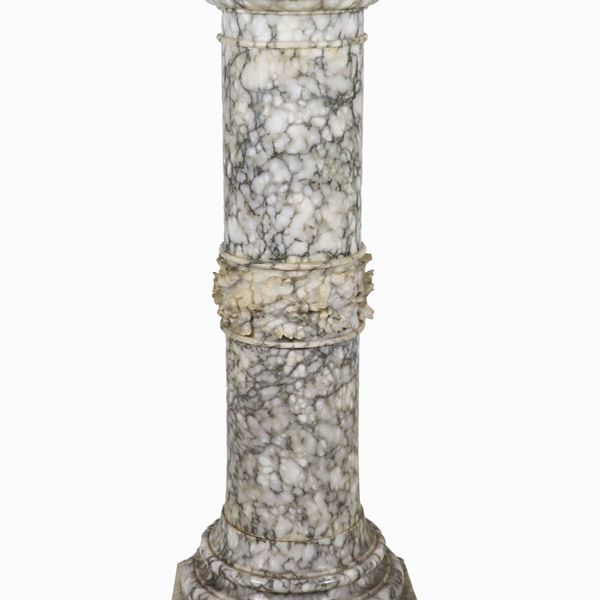 Colonna tonda rivestita in marmo grigio venato, con struttura interna vuota. Lieve mancanza