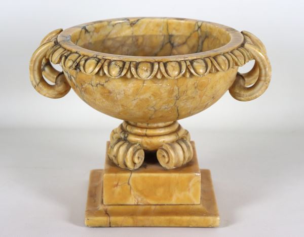 Round-shaped Roman tub in veined yellow marble, with curved handles and podded edge
