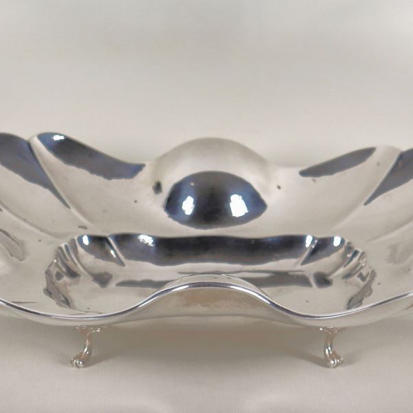 Centrotavola rettangolare in argento cesellato e sbalzato a forma sagomata, sorretto da quattro piedini ricurvi, gr. 685