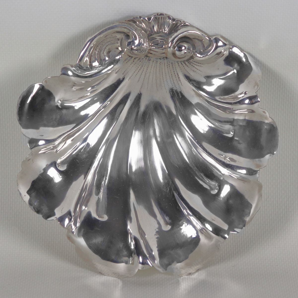 Portabonbon a forma di conchiglia in argento cesellato e sbalzato, sorretto da quattro piedini, g...