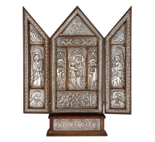 Trittico religioso in legno e metallo argentato, sbalzato e cesellato, con al centro "Madonna con Bambino e Santi"