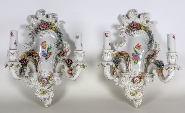 Pair of Capodimonte porcelain appliques, with polychrome decorations in relief of floral garlands, two lights each. Minor defects