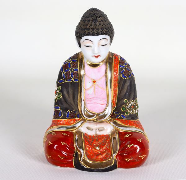 Piccola scultura orientale "Buddha" in porcellana, con decorazioni in smalto a rilievo a motivi floreali