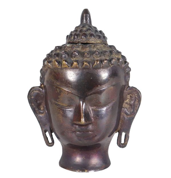 Small Buddha head in worked bronze