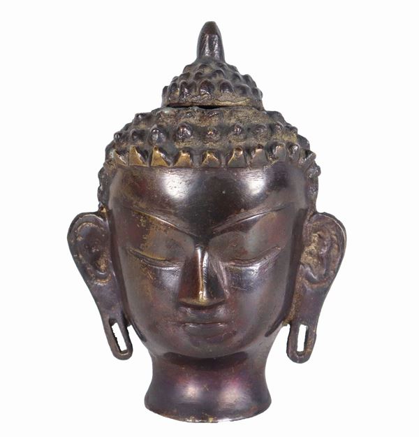 Small Buddha head in worked bronze