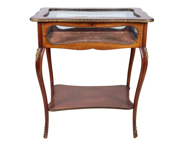 French showcase center table in walnut, with inlays of bow motifs and fruit scrolls, four curved legs joined by a shelf below