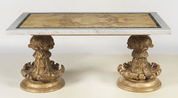 Tavolo da salotto con base formata da elementi antichi in legno dorato e intagliato a volute di foglie d'acanto, piano in marmo con tarsie geometriche