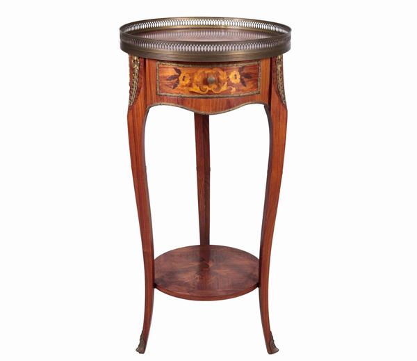 Gueridon francese a forma tonda in bois de rose ed ebano viola con intarsi a motivi floreali, piano con ringhierina traforata, tiretto centrale e quattro gambe ricurve riunite da pianetto sottostante 