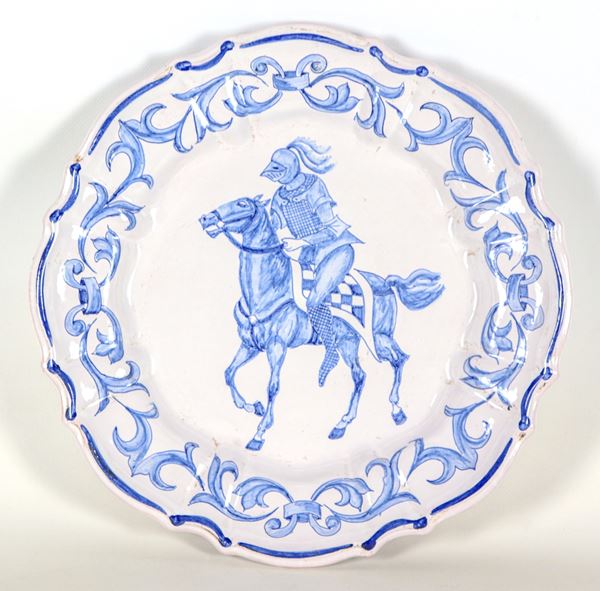 Grande piatto da muro in maiolica di Gubbio con decorazioni in blu a volute floreali, al centro 'Cavaliere con corazza'