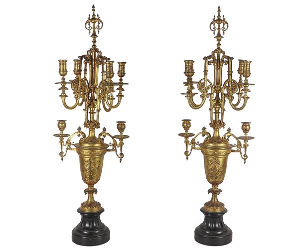Coppia di antichi candelabri francesi in bronzo dorato, sbalzato e cesellato, sorretti da basi in marmo nero, 6 fiamme ciascuno