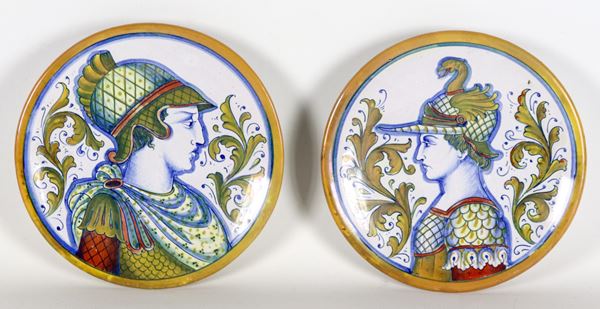 Coppia di piccoli piatti in maiolica lustrata Gualdo Tadino con al centro "Soldati con elmi", marcati Alberto Rubboli (1888-1975)