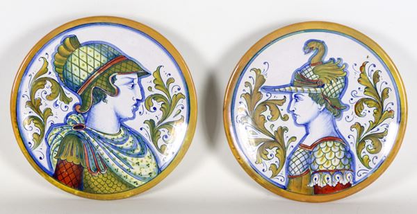 Pair of small Gualdo Tadino glazed majolica plates with "Soldiers with helmets" in the center, marked Alberto Rubboli (1888-1975)