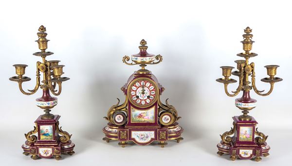 Antique French triptych Napoleon III (1852-1870), clock and two 4-flame candelabra, in red Sèvres porcelain and gilded bronze, with plaques and medallions painted with gallant scenes and bunches of flowers. Not working, to be serviced